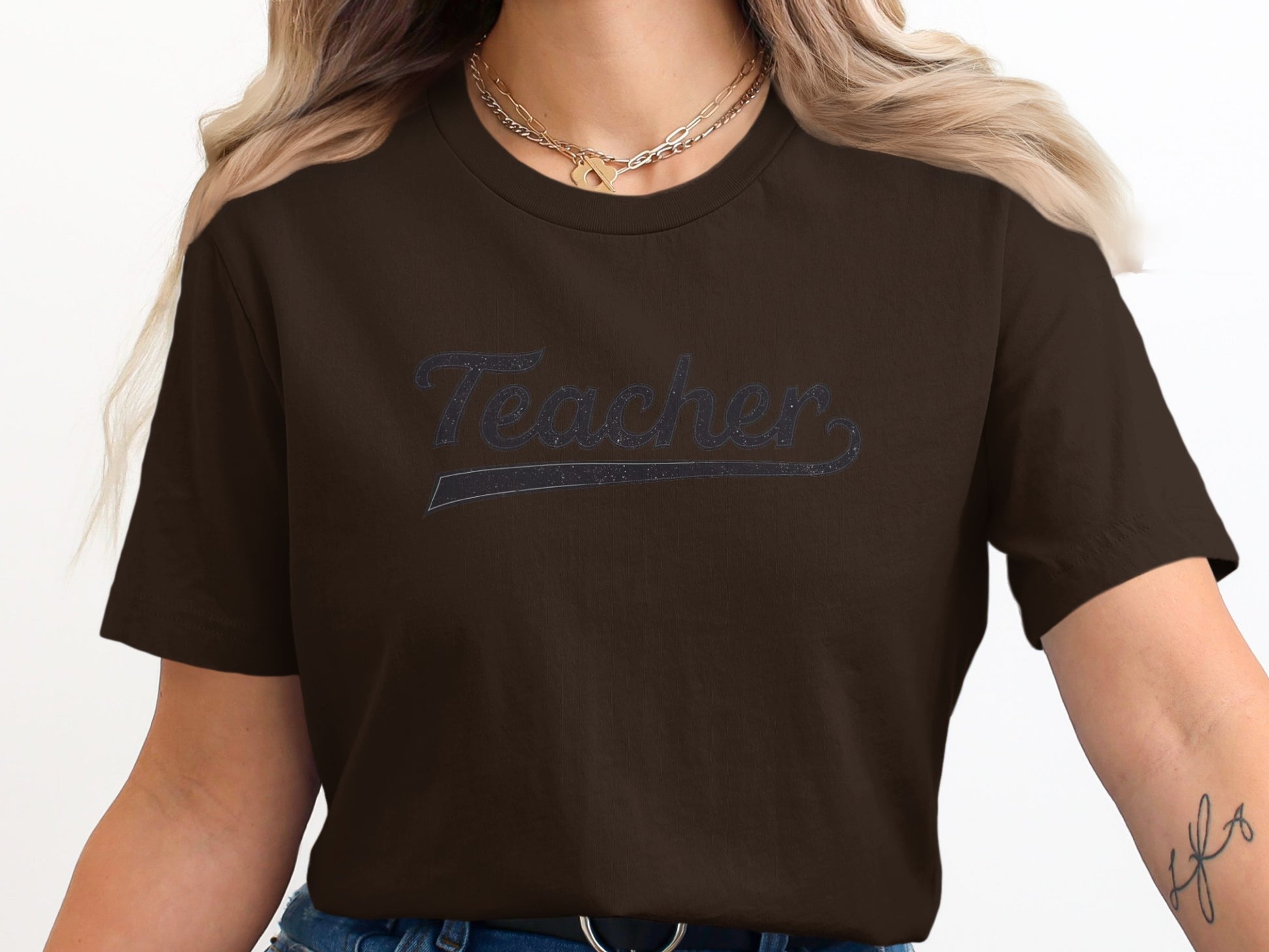 Brown t-shirt with "Teacher" text in a glittery script.