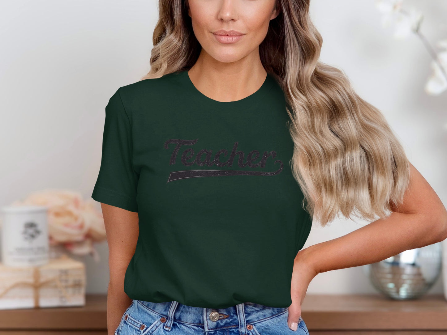 Dark green t-shirt with "Teacher" text in glittery cursive font.