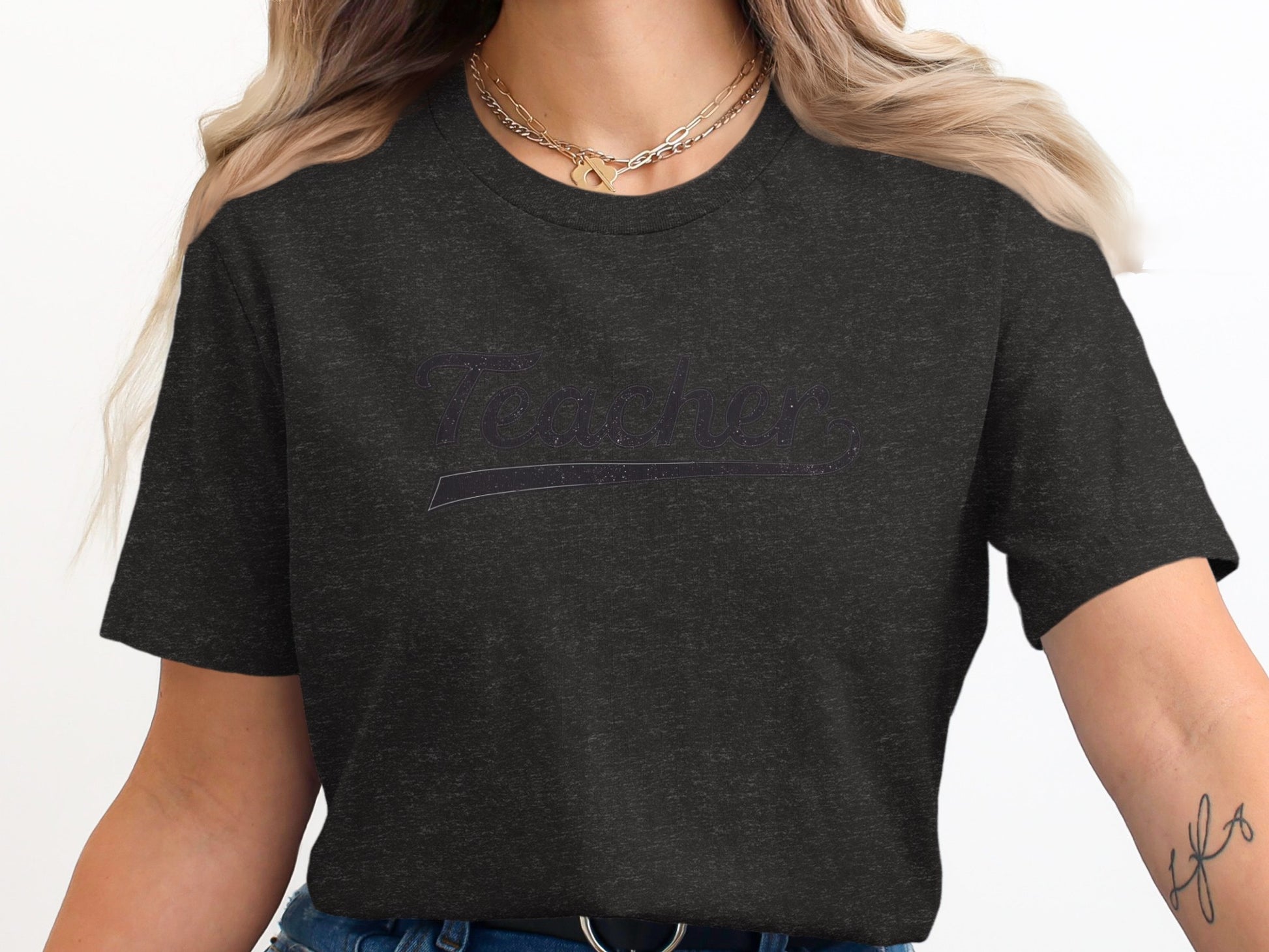 Dark grey t-shirt with "Teacher" printed in a glitter script.